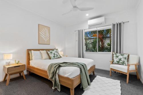 una camera da letto con un letto, una sedia e una finestra di Tide and Seek at Trinity Beach a Trinity Beach