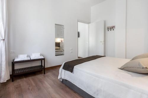 ein weißes Schlafzimmer mit einem Bett und einem Beistelltisch in der Unterkunft San Jacopino - Flo Apartments in Florenz