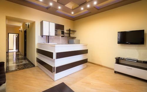 a room with a kitchen with a counter and a tv at Tatev Apartments in Yerevan