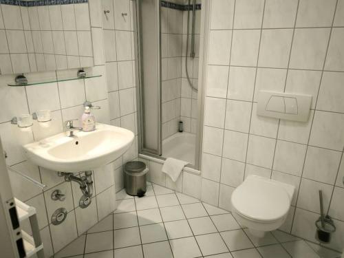 ein weißes Badezimmer mit Waschbecken und Toilette in der Unterkunft Villa Heimkehr Apartment 02 in Göhren