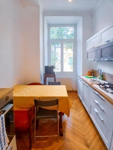 a kitchen with a table and a table and a window at Sanremo Apartments - Orchidea in Sanremo