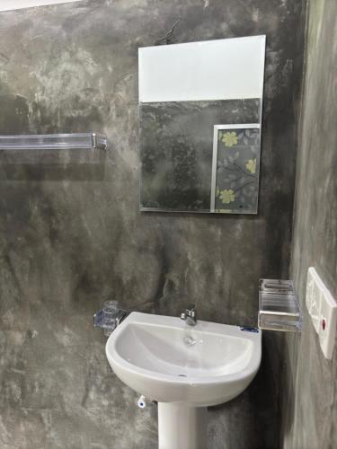 a bathroom with a sink and a picture on the wall at Noble Nest Hirikatiya in Dickwella