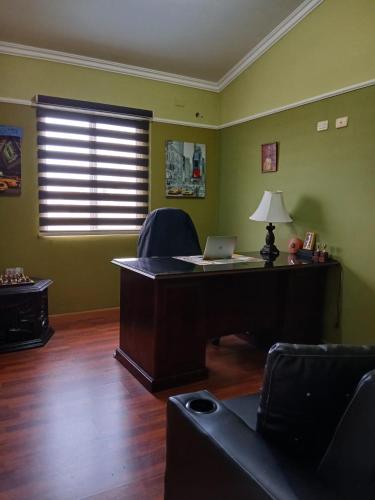 an office with a desk with a laptop on it at El Sauce, casa zona exclusiva in Tegucigalpa