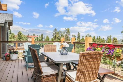 a patio with a table and chairs on a deck at Breck Mountain Getaway home in Overlook Athletic Club Heliport