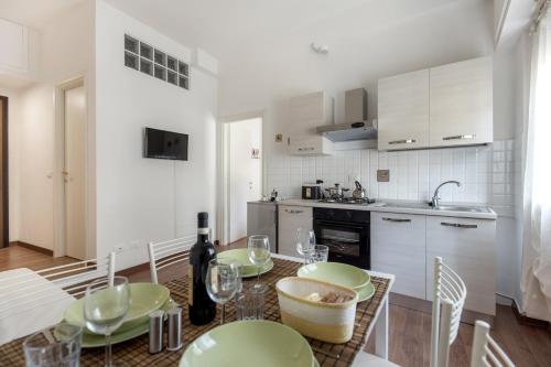una cocina con una mesa con platos verdes. en San Jacopino - Flo Apartments, en Florencia