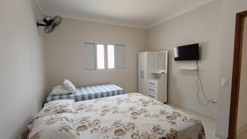 - une petite chambre avec un lit et une télévision dans l'établissement Chácara Santa Luzia, à Socorro