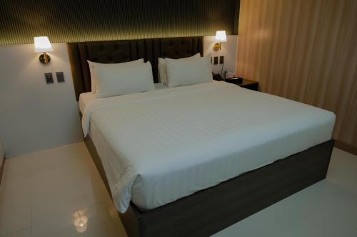 a bedroom with a large bed with white sheets and pillows at THE TIMES HOTEL in Angeles