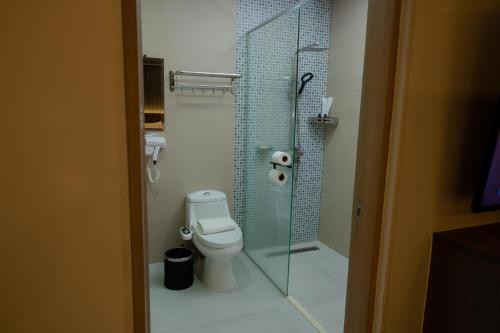 a bathroom with a toilet and a glass shower at THE TIMES HOTEL in Angeles