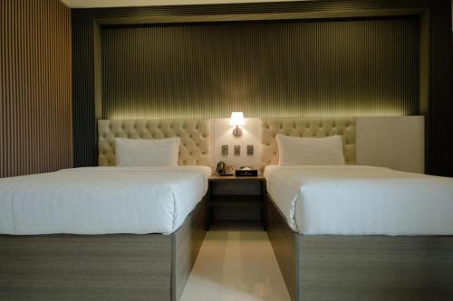 two beds in a hotel room with a bedsenalsenalsenalsenalsenalsenal at THE TIMES HOTEL in Angeles