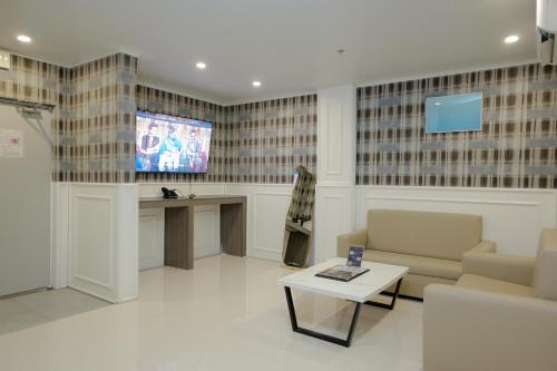 a living room with a tv and a couch and a table at THE TIMES HOTEL in Angeles