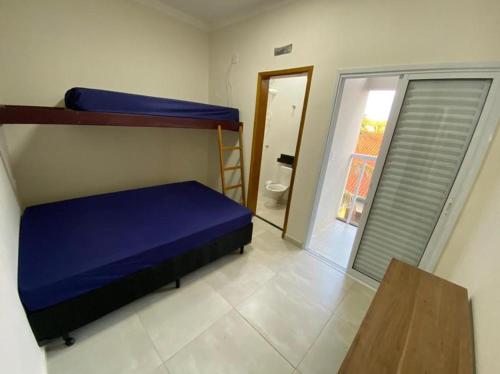 a bedroom with two bunk beds and a bathroom at Rancho do Rinoceronte - Miguelópolis in Miguelópolis