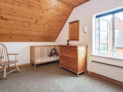 a room with a crib and a wooden ceiling at 6-Person Home in Ærøskøbing-By in Ærøskøbing