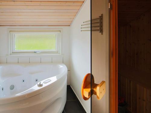 a white tub in a bathroom with a window at Luxury Retreat with Spa - By Traum Ferienwohnungen in Dannemare
