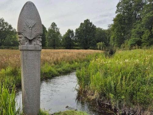 a stone monument in a field next to a river at 5 star holiday home in Hovborg-By Traum in Hovborg