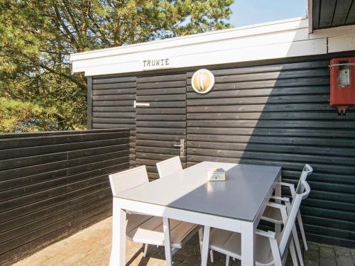 a table and chairs in front of a fence at 4 person holiday home in Fanø-By Traum in Fanø