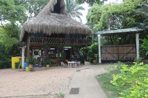 a small hut with a thatched roof and a patio at Eco Hotel El Reposo in Melgar