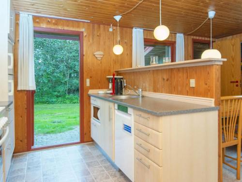 a kitchen with wooden walls and a counter with a sink at 6 person holiday home in Struer-By Traum in Struer