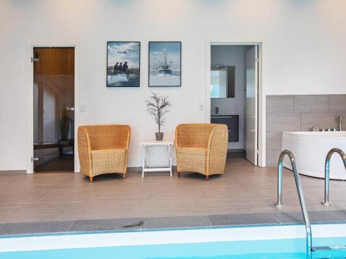 a room with a swimming pool and two chairs and a table at Luxury Retreat in Klitmoller - By Traum Ferienwohnungen in Torsted