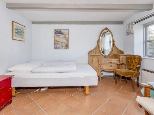 a bedroom with two beds and a mirror and a chair at Historic Charm by Lild Strand-By Traum in Frøstrup