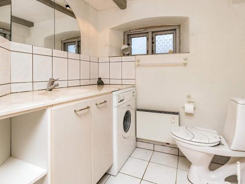 a white bathroom with a toilet and a sink at Historic Charm by Lild Strand-By Traum in Frøstrup