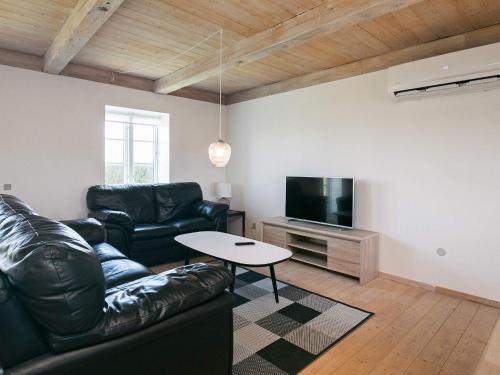 a living room with a leather couch and a tv at 7 person holiday home in Faaborg-By Traum in Fåborg