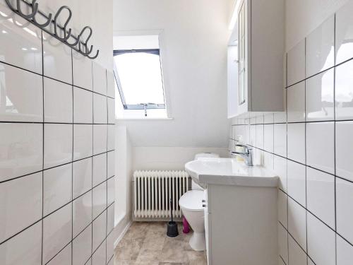 a white bathroom with a toilet and a sink at 3 person holiday home in Ærøskøbing-By Traum in Ærøskøbing