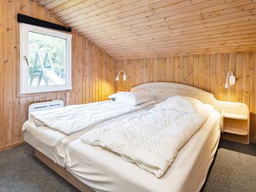 - une chambre avec un grand lit dans un mur en bois dans l'établissement Luxury Pool House Retreat - By Traum Ferienwohnungen, à Saltum