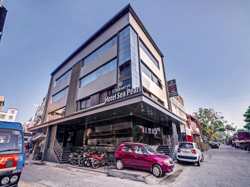 a red car parked in front of a building at Super Townhouse Edasserys Sea Pearl in Cochin