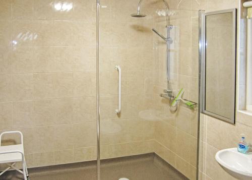 a bathroom with a glass shower with a sink at Oak Farm Lodges in Roydon