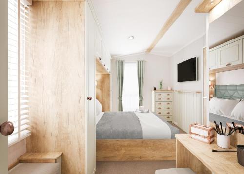 a bedroom with a bed and a television in it at Aber Bay Holiday Park in Aberystwyth