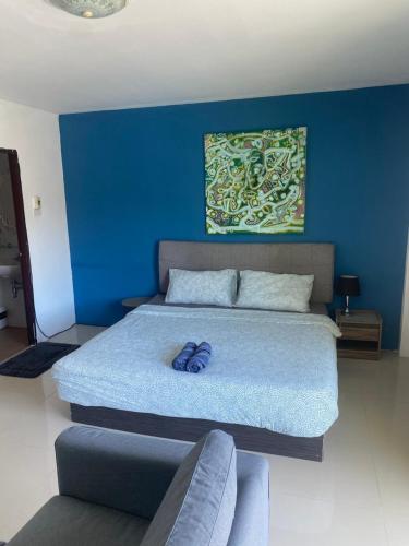 a bedroom with a large bed with a blue wall at English owned Homestay and Yoga in Chalong 