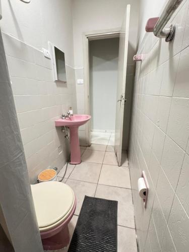 ウベラバにあるComforto-1 min ABCZl 4 min BR050のバスルーム(ピンクのシンク、トイレ付)