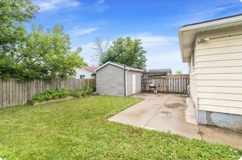 a backyard of a house with a fence at Quaint and Stylish UPPER level 3-bed bungalow in Hamilton, ON in Hamilton