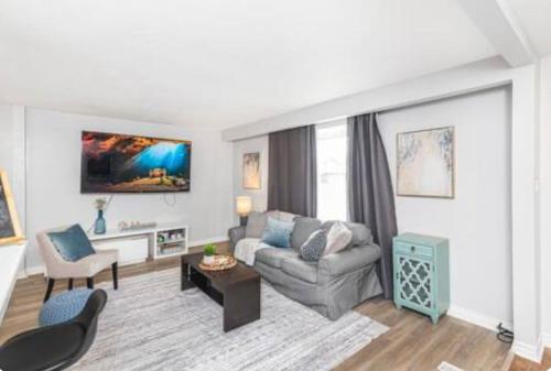 a living room with a couch and a table at Quaint and Stylish UPPER level 3-bed bungalow in Hamilton, ON in Hamilton