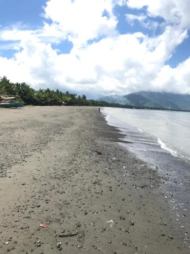 a view of a beach with rocks and the ocean at Casa Bambú in Pantukan