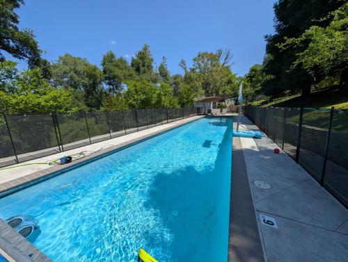 a swimming pool with a fence around it at The Blue Resort of Yosemite - Pool, Spa, Games in Mariposa
