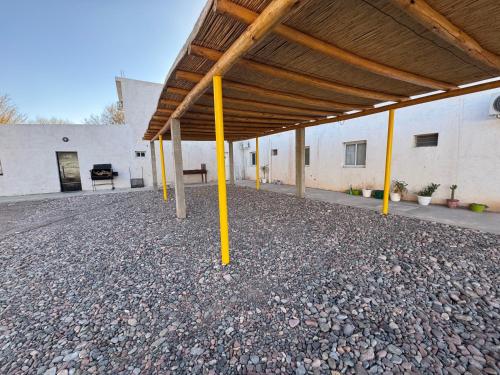 a building with yellow poles and a roof at Atrapasueños fiambala in Tinogasta