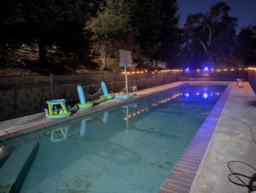 a swimming pool at night with chairs in it at The Blue Resort of Yosemite - Pool, Spa, Games in Mariposa