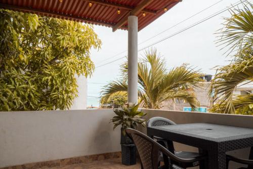 a table and chairs on a balcony with palm trees at Cabaña las Palmas Rincon del Mar in Rincón