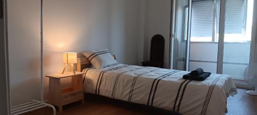 a bedroom with a bed and a lamp and a window at CarriCHe 2 in Lisbon