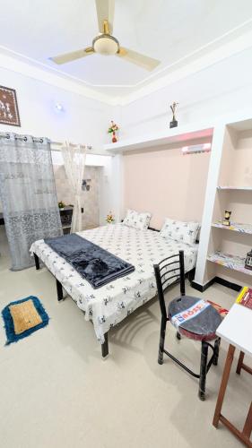 a bedroom with a bed and a chair in it at Krishnaalay Guest House in Ujjain