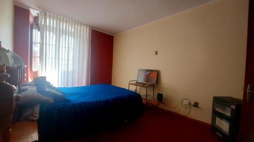 a bedroom with a blue bed and a window at Departamento céntrico bello lugar turístico in Sucre