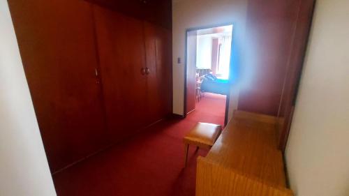 a hallway with a chair and a door to a room at Departamento céntrico bello lugar turístico in Sucre