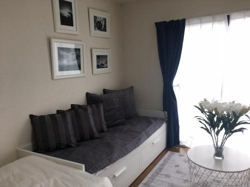 a couch in a bedroom with a window and a table at Apartment in Narita 117 in Narita