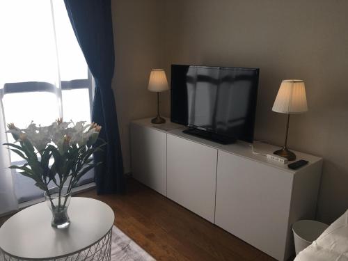 a living room with a flat screen tv on a white cabinet at Apartment in Narita 117 in Narita