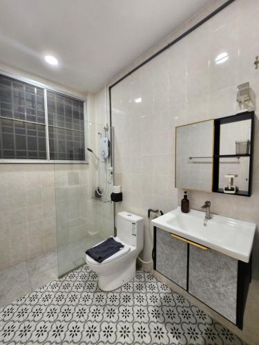 a bathroom with a toilet and a sink and a shower at Ipoh pasir puteh vibrant home 4br 15 pax in Ipoh