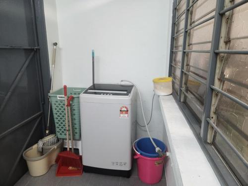 a small refrigerator in a room with buckets at Ipoh pasir puteh vibrant home 4br 15 pax in Ipoh