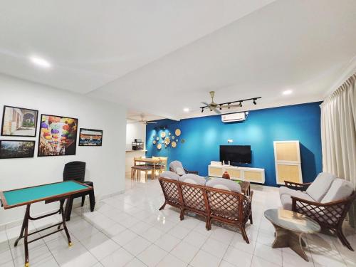 a living room with a blue wall at Ipoh pasir puteh vibrant home 4br 15 pax in Ipoh