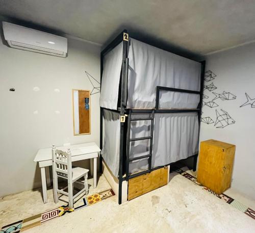 a room with a tent and a desk and a table at Maui Hostels Tulum in Tulum