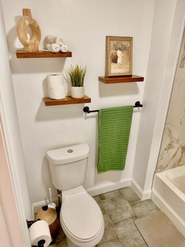 a bathroom with a toilet and a green towel at Spacious 3BR Apartment - 12min Newark Airport -Near NYC & Malls in Newark
